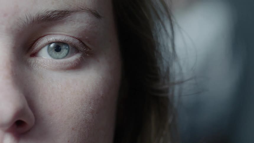 A woman blinks and opens her eye