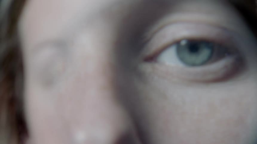Person's eyes looking through a piece of rounded glass