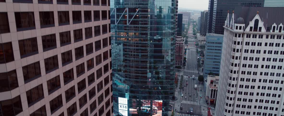 Cars drive through city filled with skyscrapers