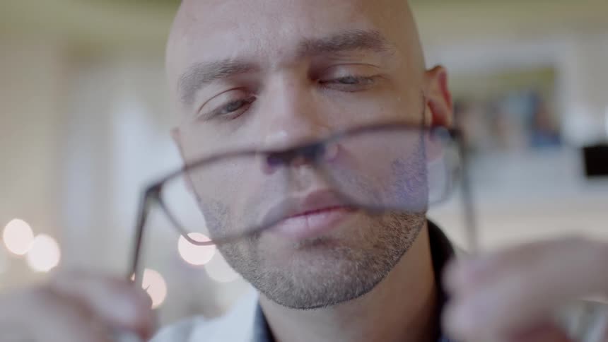 A doctor is holding a pair of glasses and examining them