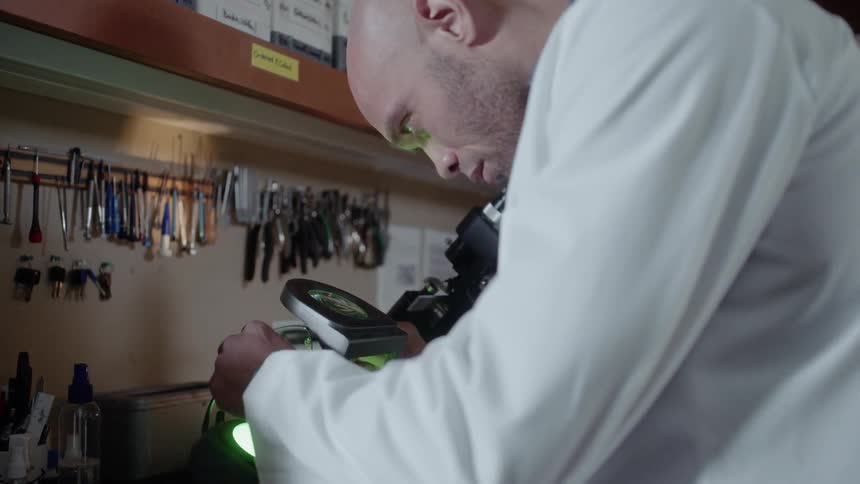 An optometrist is working with a microscope in an office