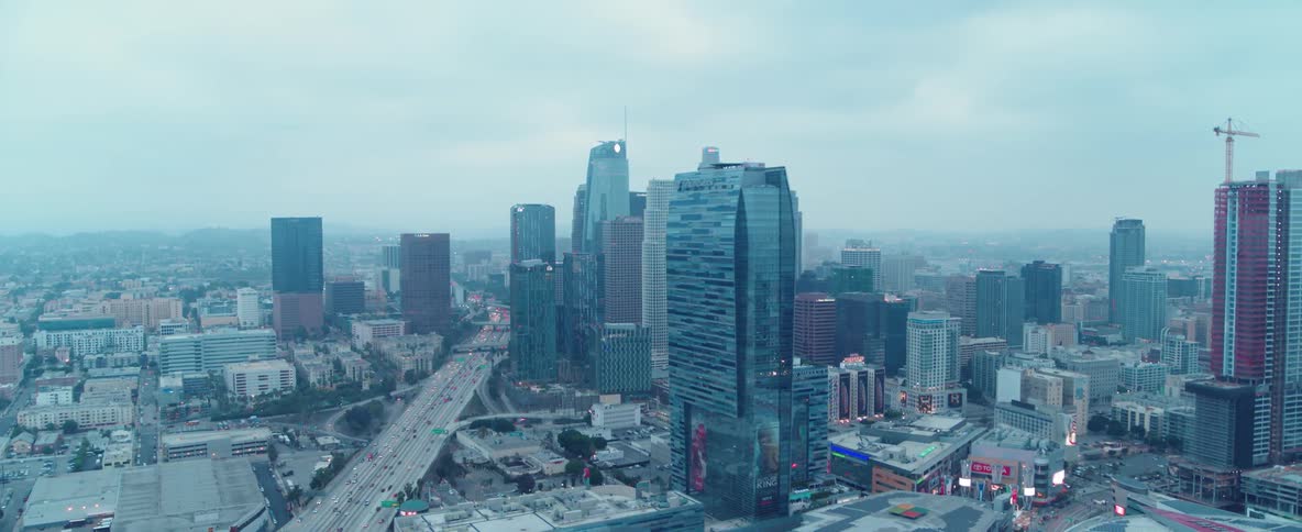 Cars travel on a city highway near the skyscrapers