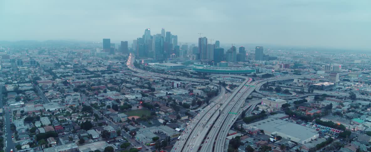 Traffic moving on a large freeway with a large city in the background