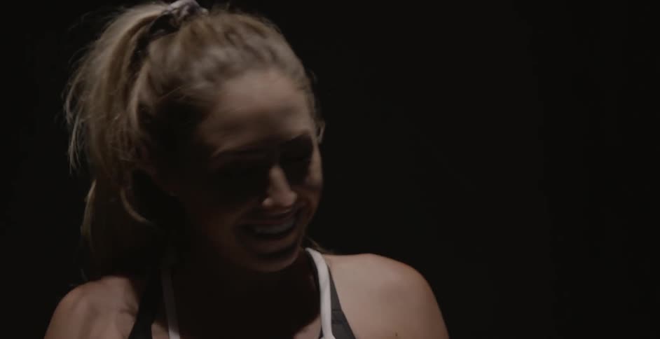 A woman smiles as she exercises in the dark