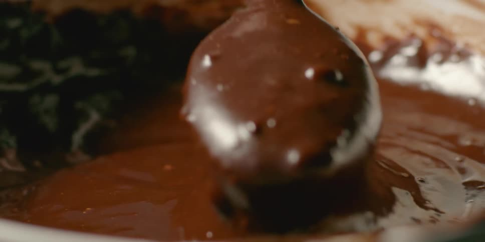 A spoon stirs melted chocolate
