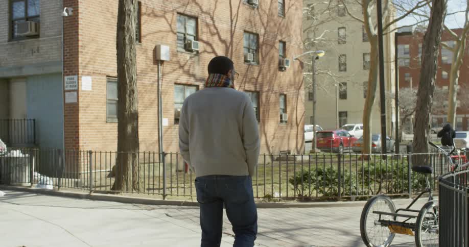 A man walks on a city sidewalk