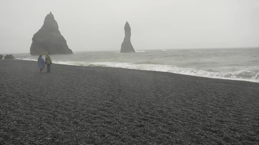 Two people standing on a foggy beach