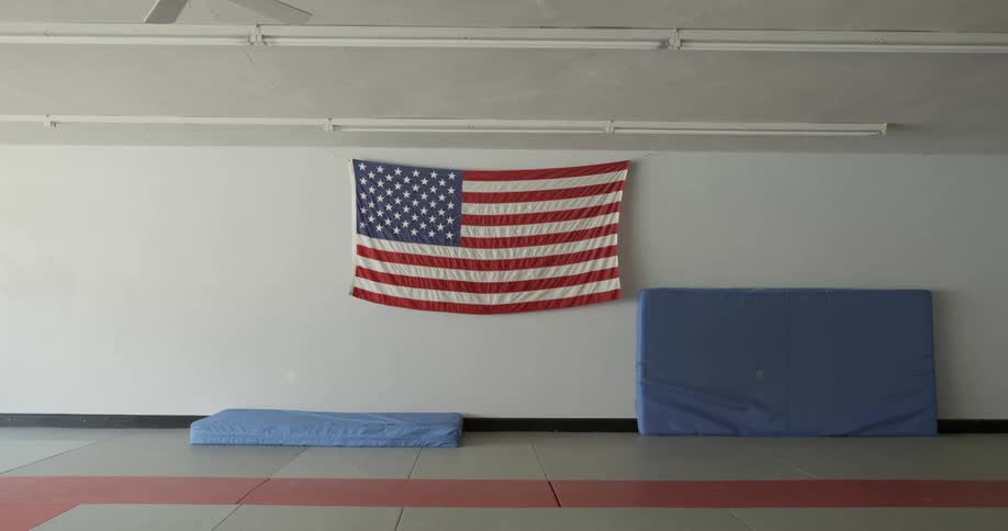An american flag hangs on the wall near mats
