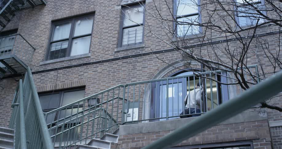 A man is walking through the doors of an office building