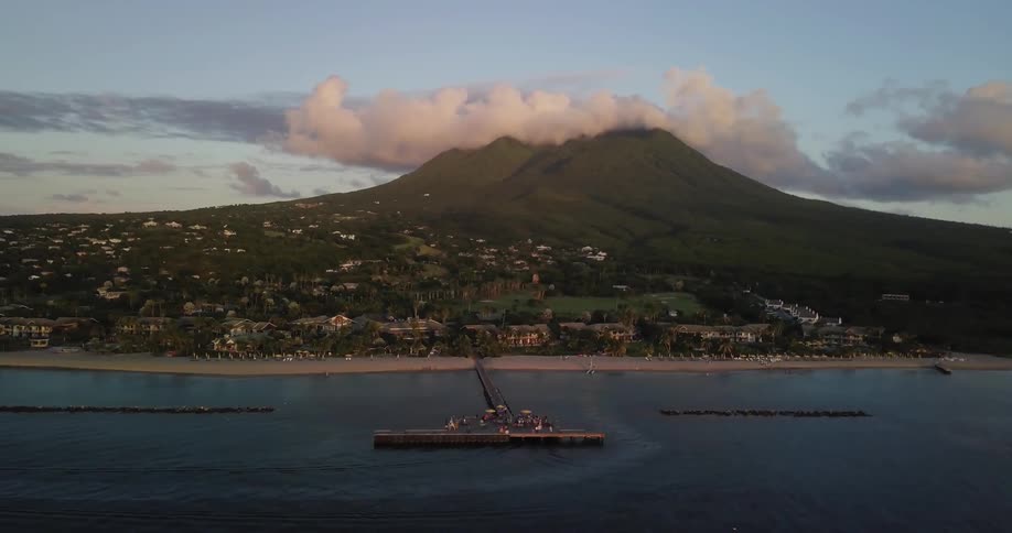 Clouds hanging over a mountain that sits behind a large waterway