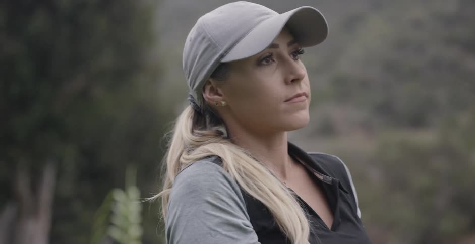 A female golfer is practicing her swing outside during the day