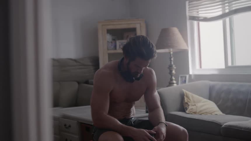 A man is sitting in thought in his living room during the day
