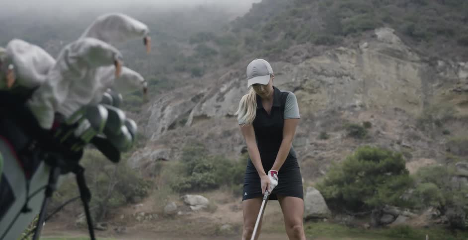 Woman lines up a golf shot