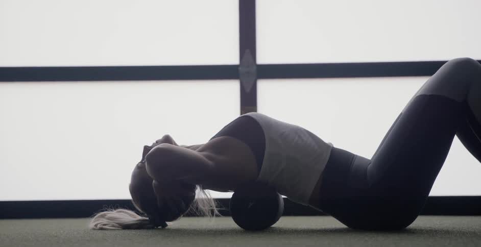 A woman does sit ups in a gym