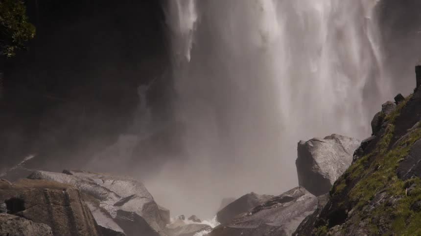 Waterfall falling down into a pool of water by rocks