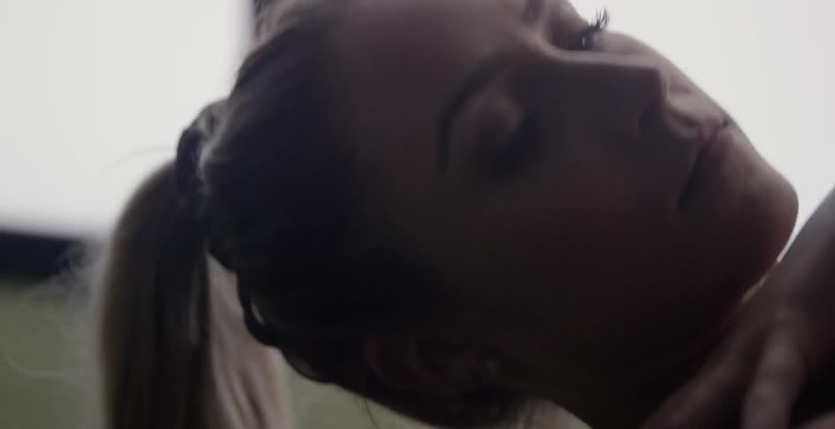 A woman laying on the floor stretches her shoulders side to side