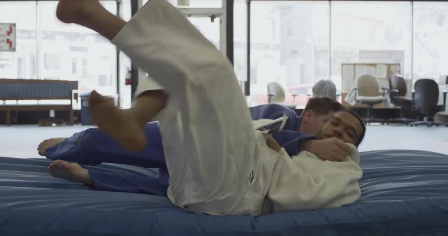 Two men spar in a karate dojo