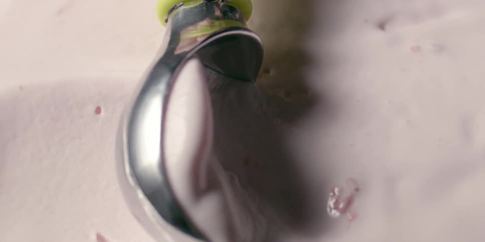 An ice cream scoop glides across ice cream