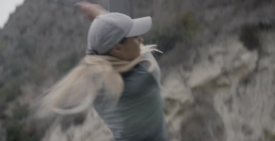 A woman golfs on a driving range