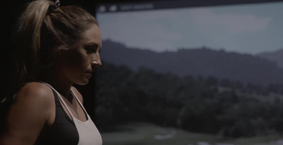 Woman prepares to swing a golf club