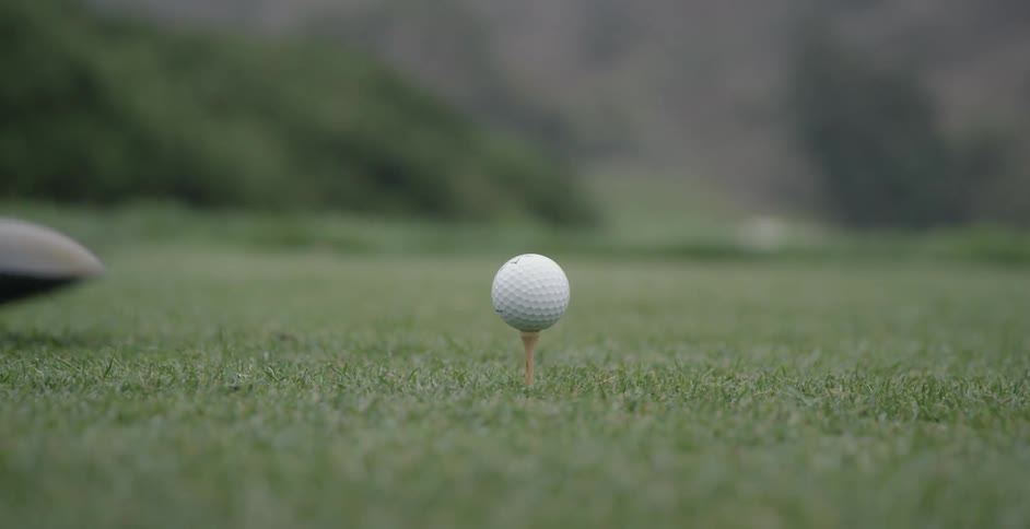 Someone is placing a golf ball on a tee