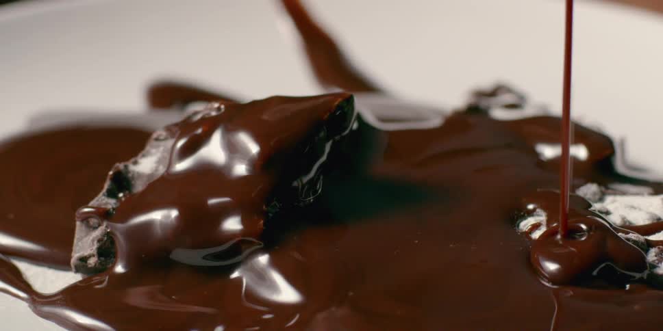 Chocolate sauce is being drizzled over a dessert