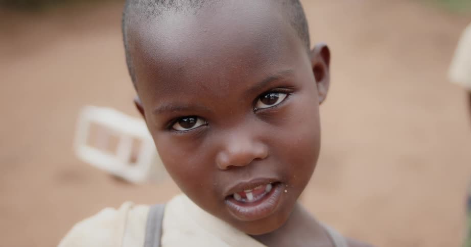 A child standing outside smiles