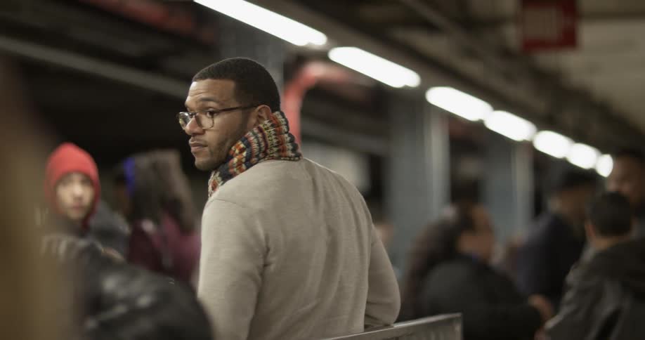 Commuters stand in a subway station