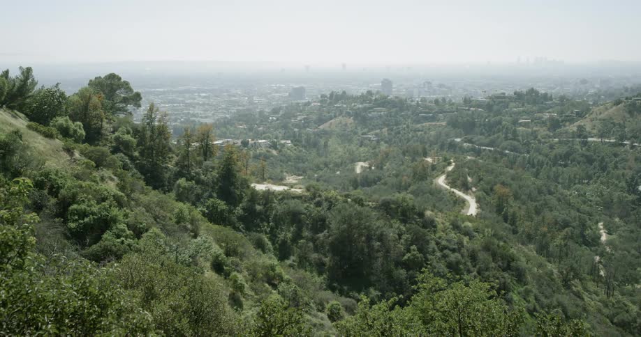 Smog is hanging over a city in a valley during the day