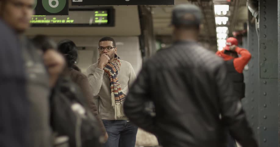 A man is waiting in a commuter train station
