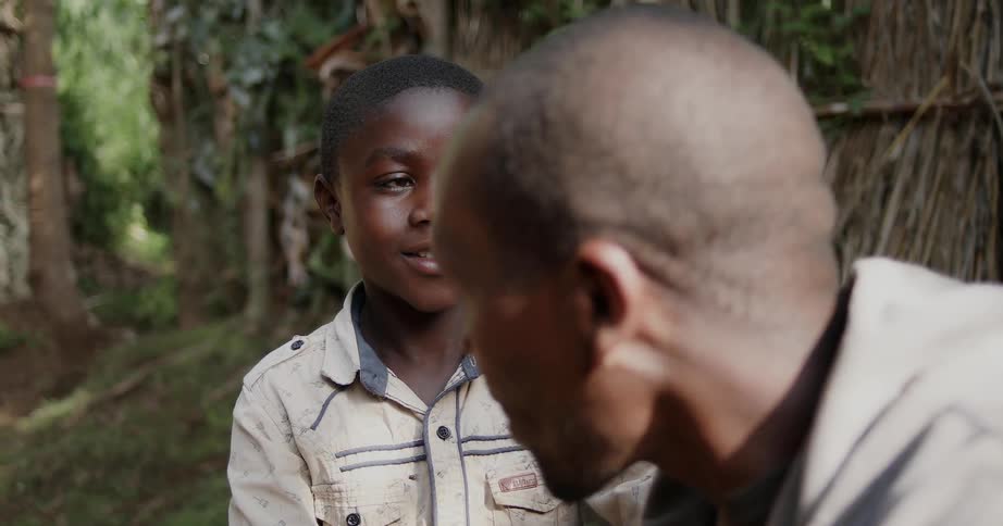 A man and boy talk in a forest