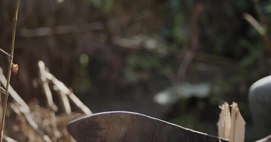 A piece of wood is cut with a machete