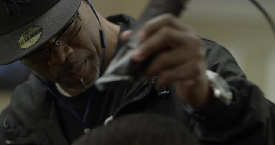 A man is cutting someone else's hair with clippers