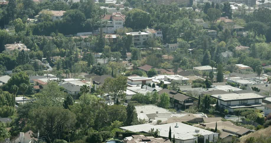 A city neighborhood is viewed from a hill