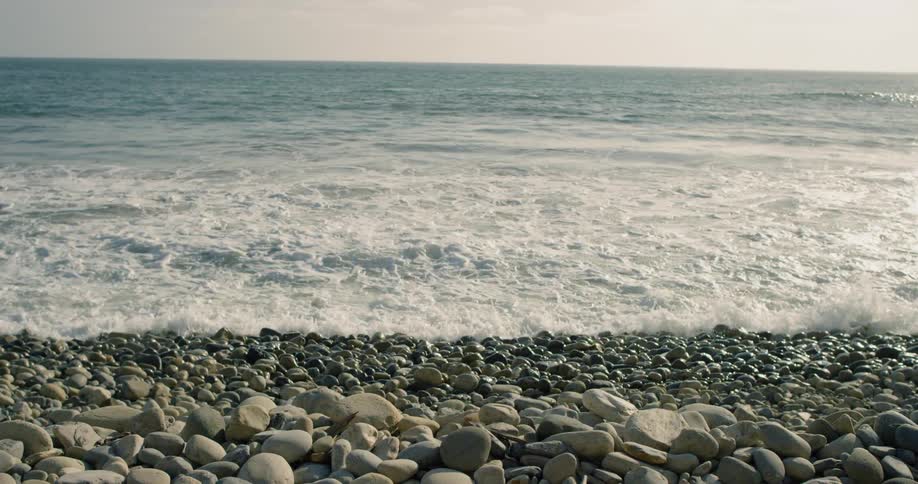 Small waves coming ashore on a rocky beach