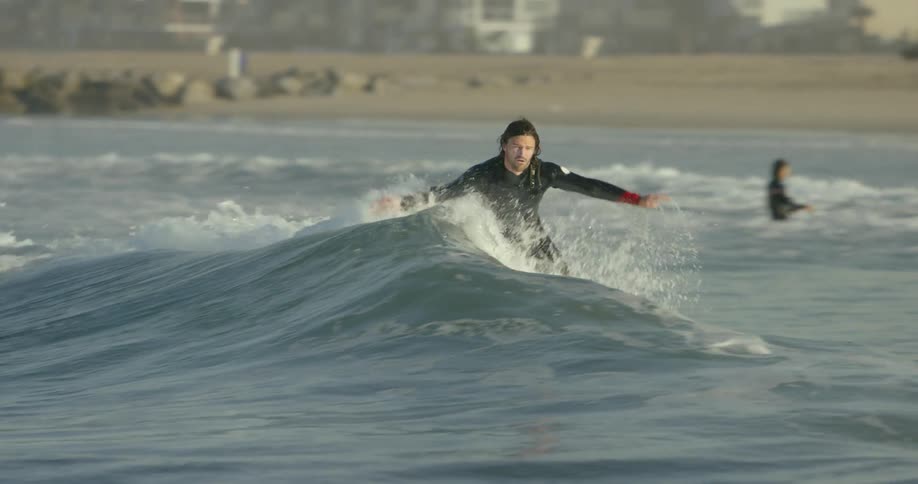 A man surfs on an ocean wave