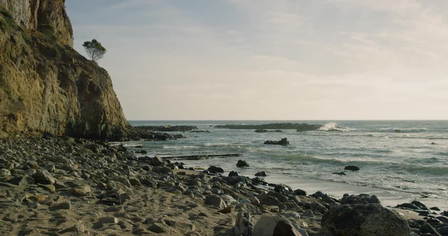 Ocean waves wash ashore a rocky beach