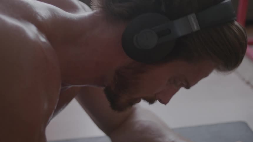 A man sweats while exercising on a mat