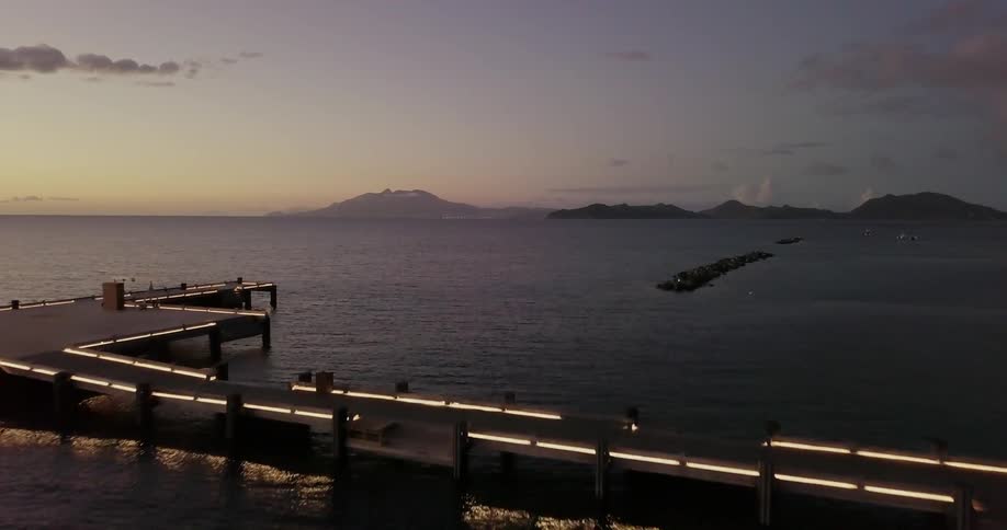 A pier and dock extend out into the ocean