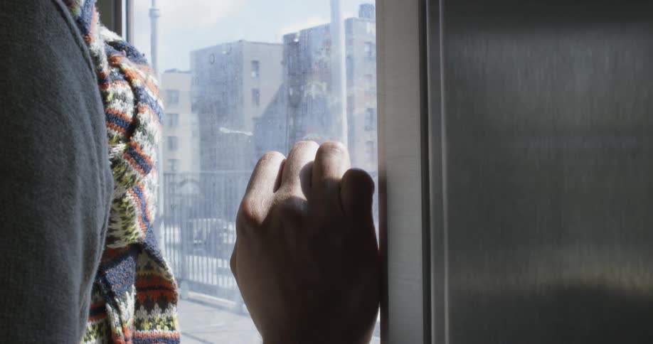 A person is leaning against the window of a moving train