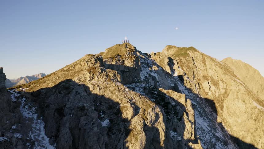 Hikers stand on a snowy mountain peak