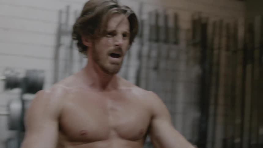 A shirtless man exercises on a row machine