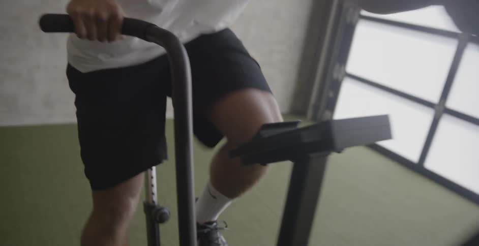 Man cycles on indoor exercise machine