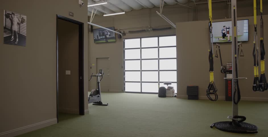 Televisions are playing inside a gym during the day