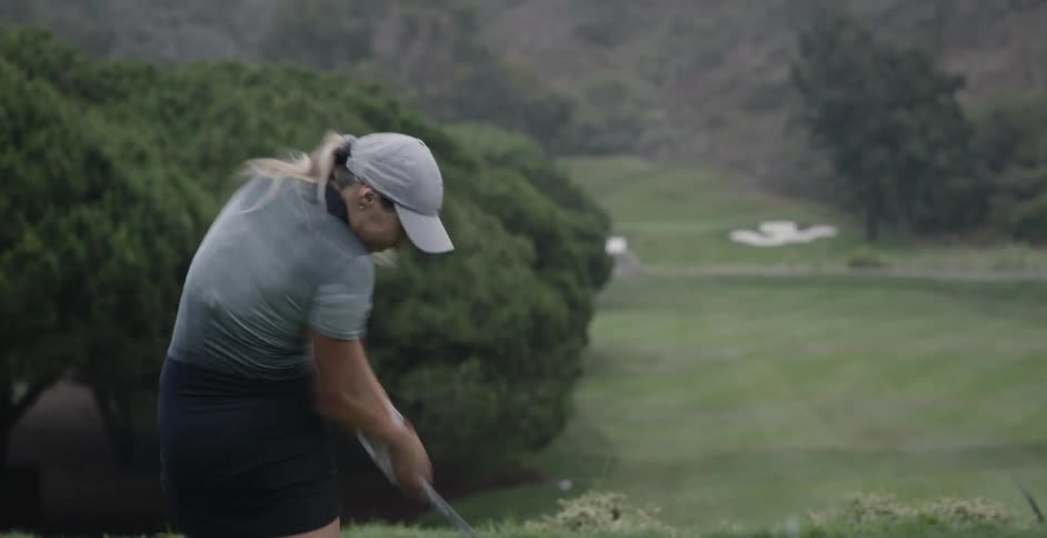 Woman hits golf ball with her driver