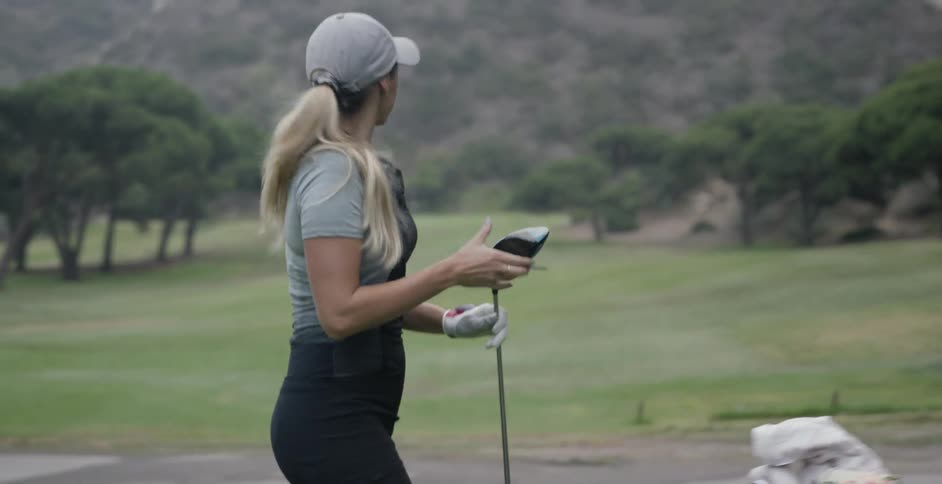 A woman golfs on a golf course