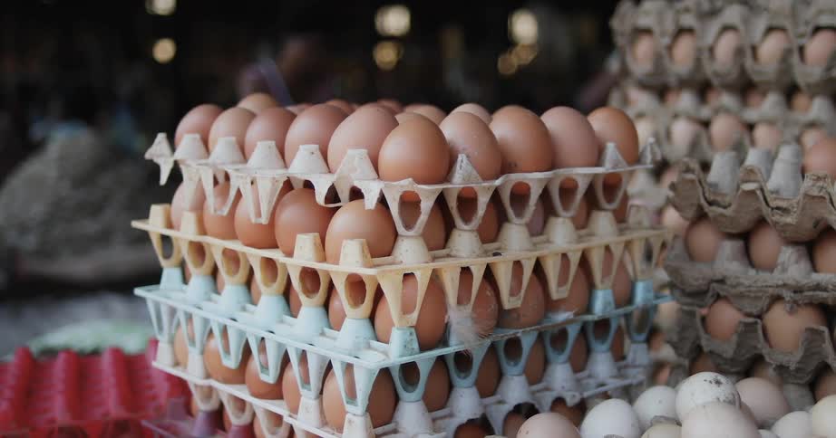Brown eggs in cartons stacked on top of each other