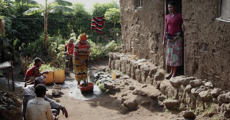 People are washing clothes and sitting in a yard