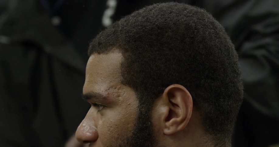 A barber brushes a man's hair