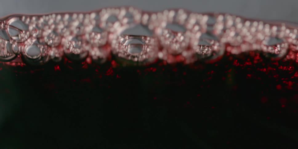 Red wine is poured into a glass